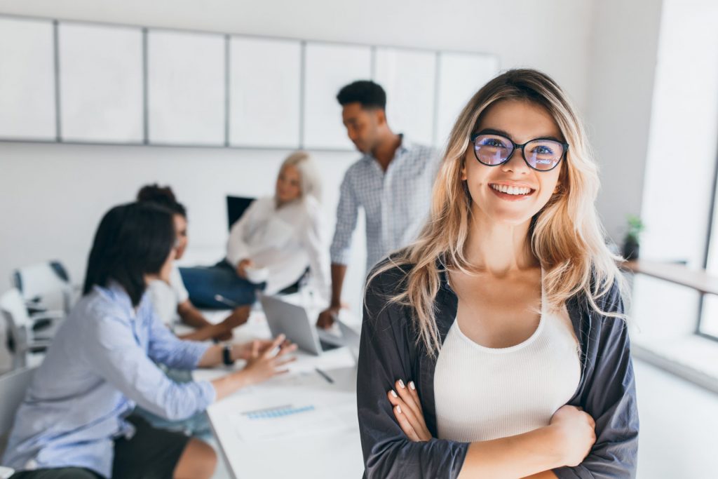 blonde-female-executive-posing-with-smile-and-arms-crossed-during-brainstorm-with-managers-indoor-portrait-of-european-student-spending-time-in-hall-with-asian-and-african-friends Team